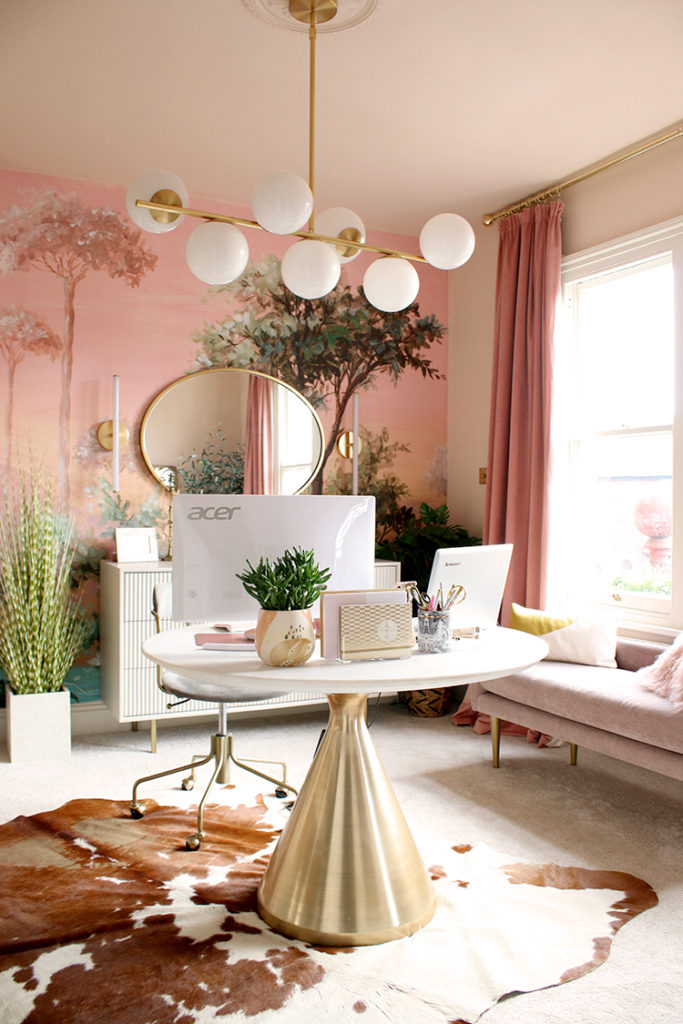 nice home office with peach colored wall paper and beautiful desk and decor