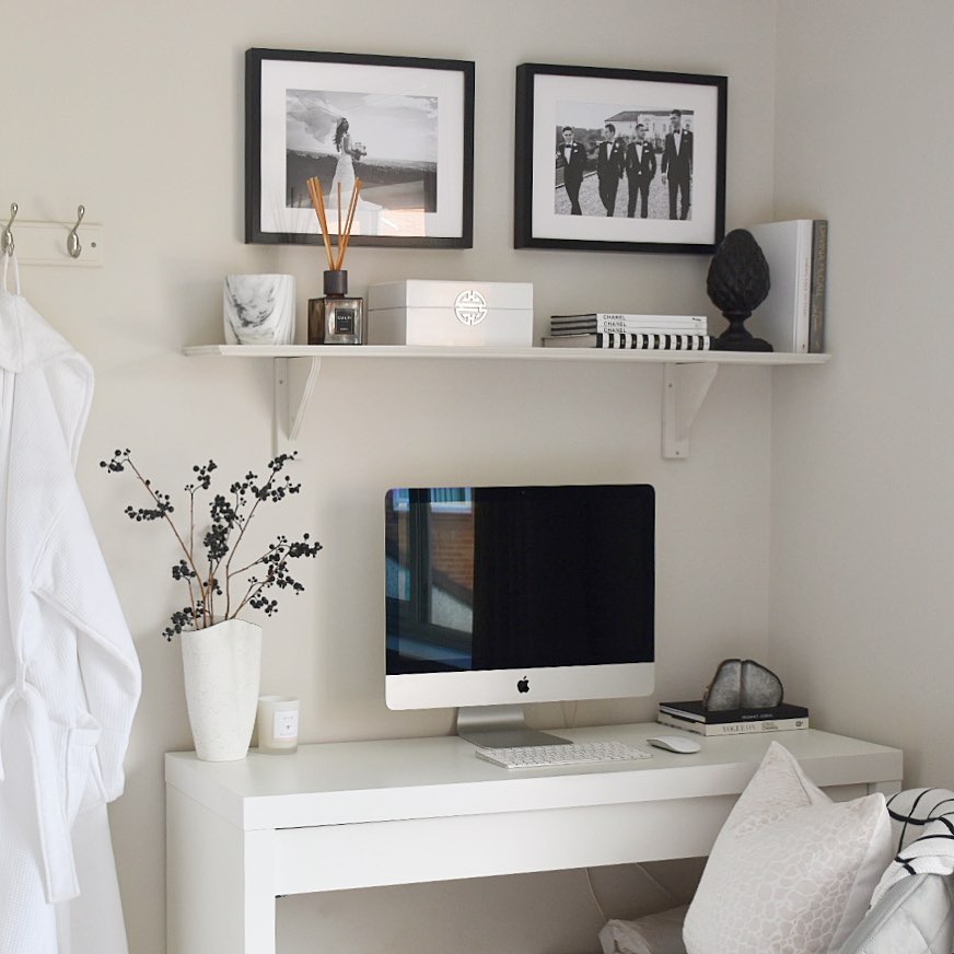 Cozy home office with white wall, table, and desktop computer