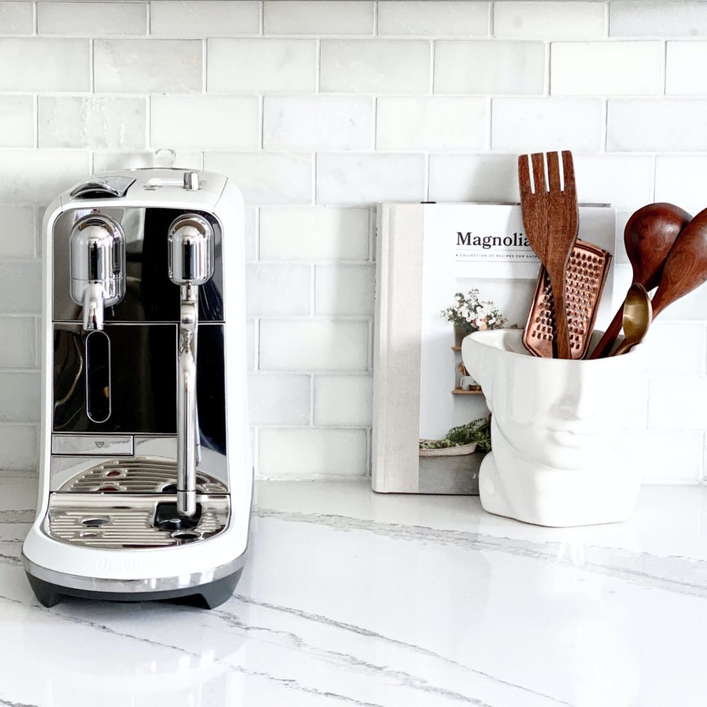 Coffee machine and wooden utensils in the kitchen counter.