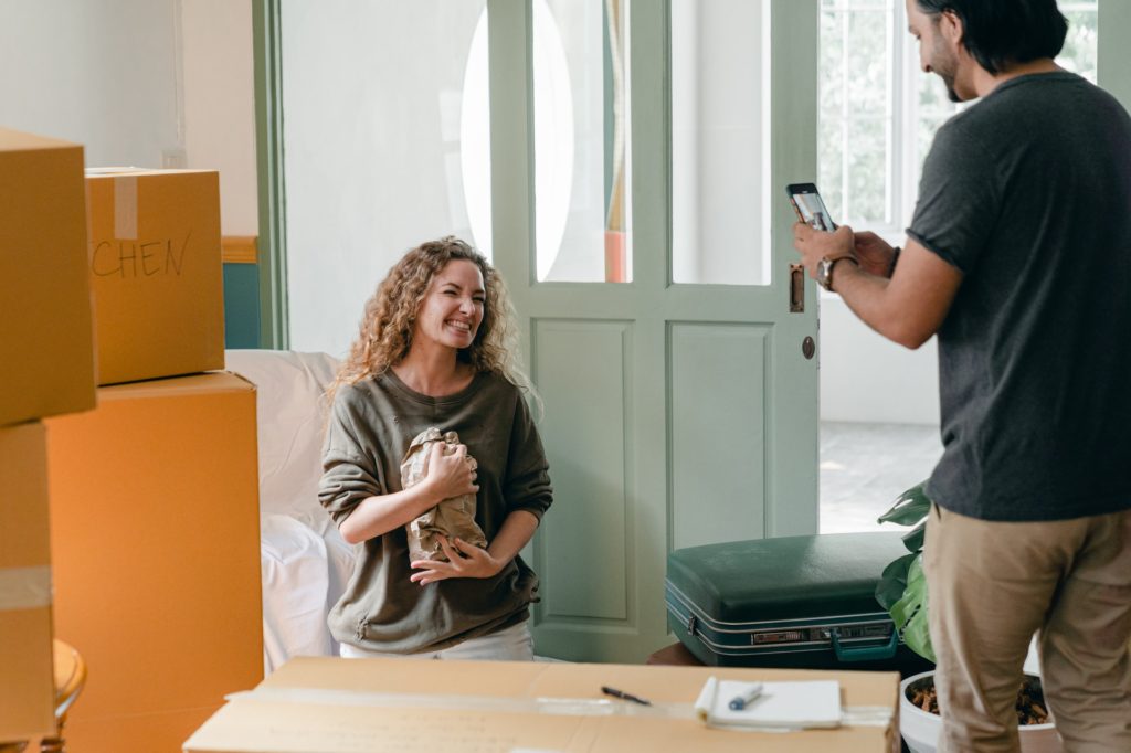 Man taking a photo of a lady while moving out of house