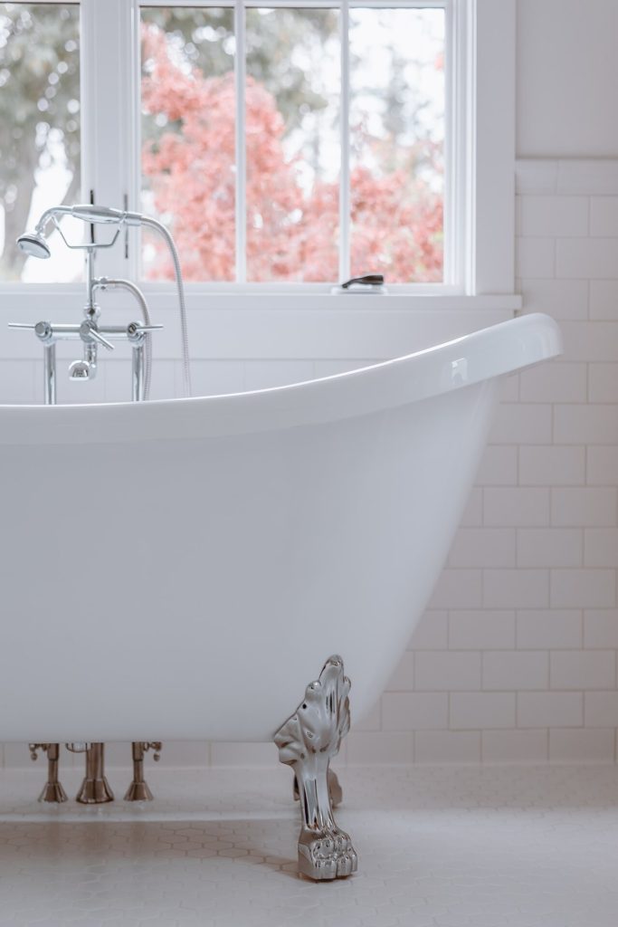 White bath tub in a clean and white bathroom