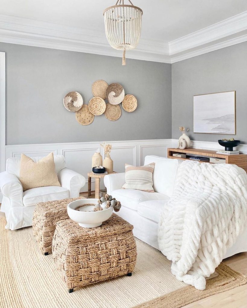 Light gray living room filled with a white sofa, two wicker chairs at the center, and a nice wall with baskets