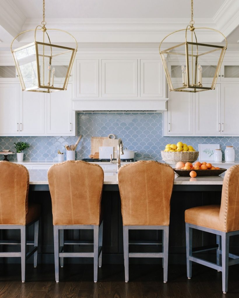 White kitchen with leather barstool chairs.