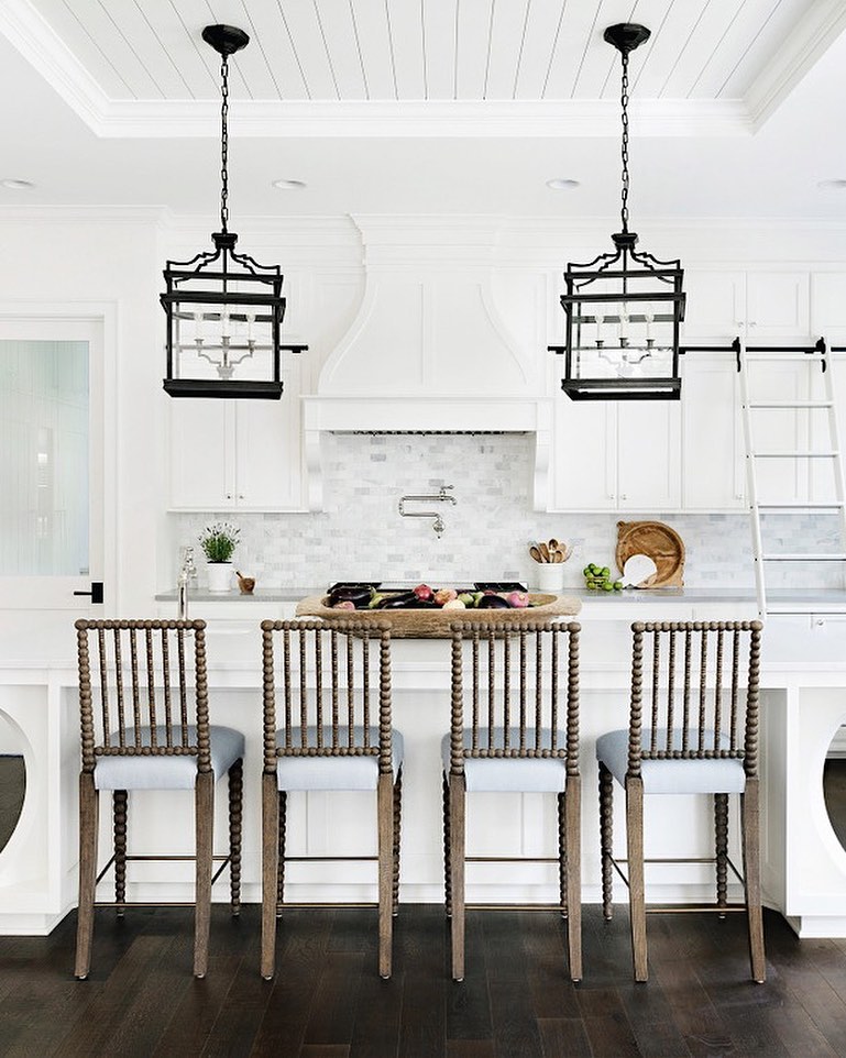 All-white kitchen with black pendant lanterns.