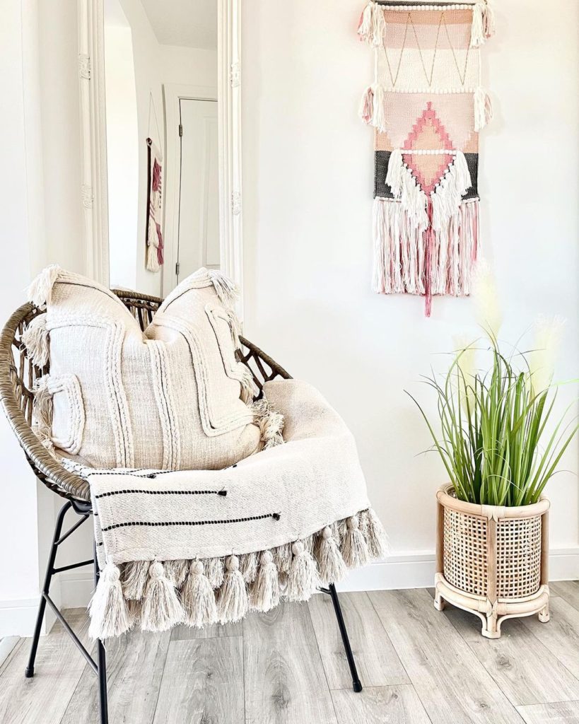 Pompom blanket and pillow in a chair.