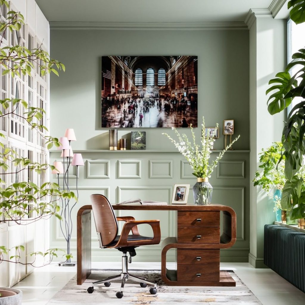 Home office with light green paint and plants