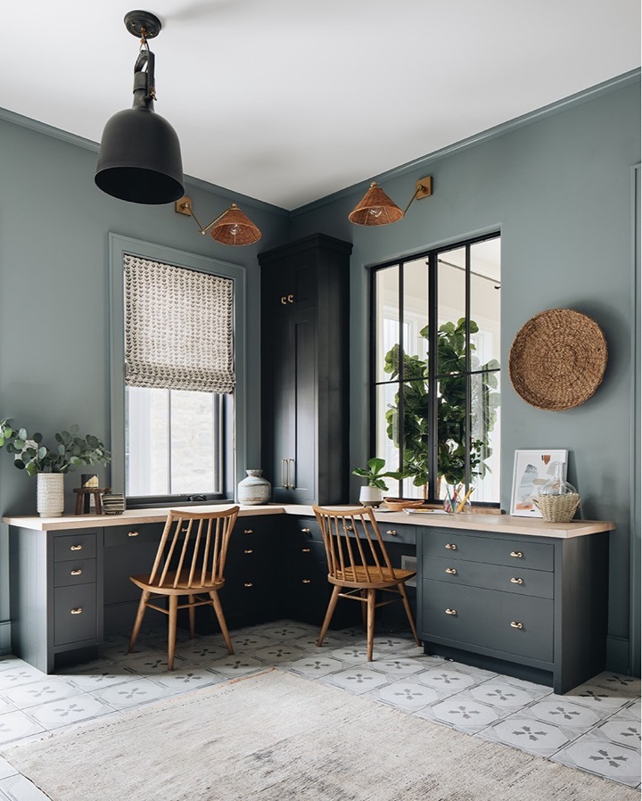 Light gray office with two tables and rattan sconce