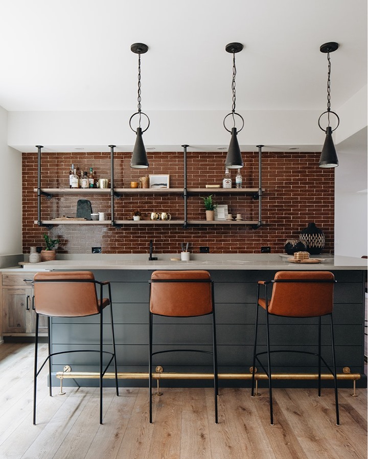 Kitchen with rust-colored bricks and dark counter. 