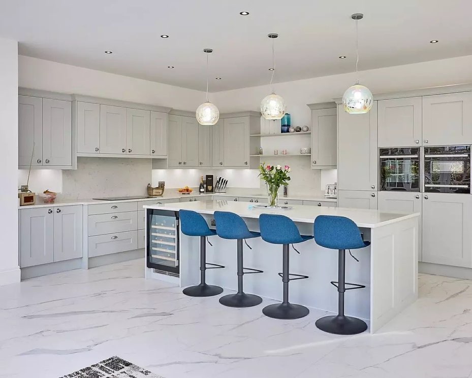 White modern kitchen with bright blue kitchen stools. 