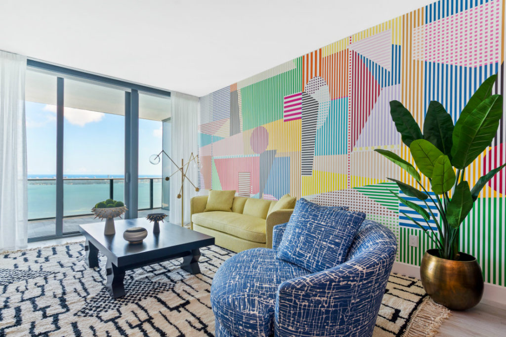 Modern living room with abstract wall paper and colorful furniture in various patterns