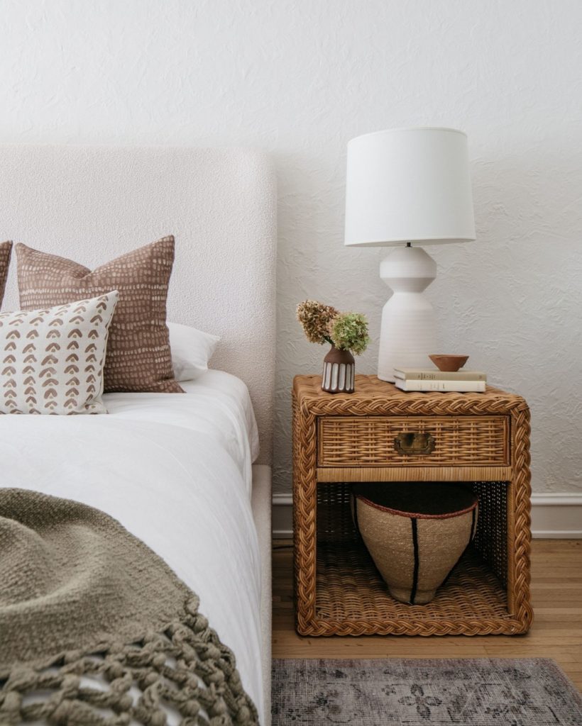 Wicker end table and white bed 