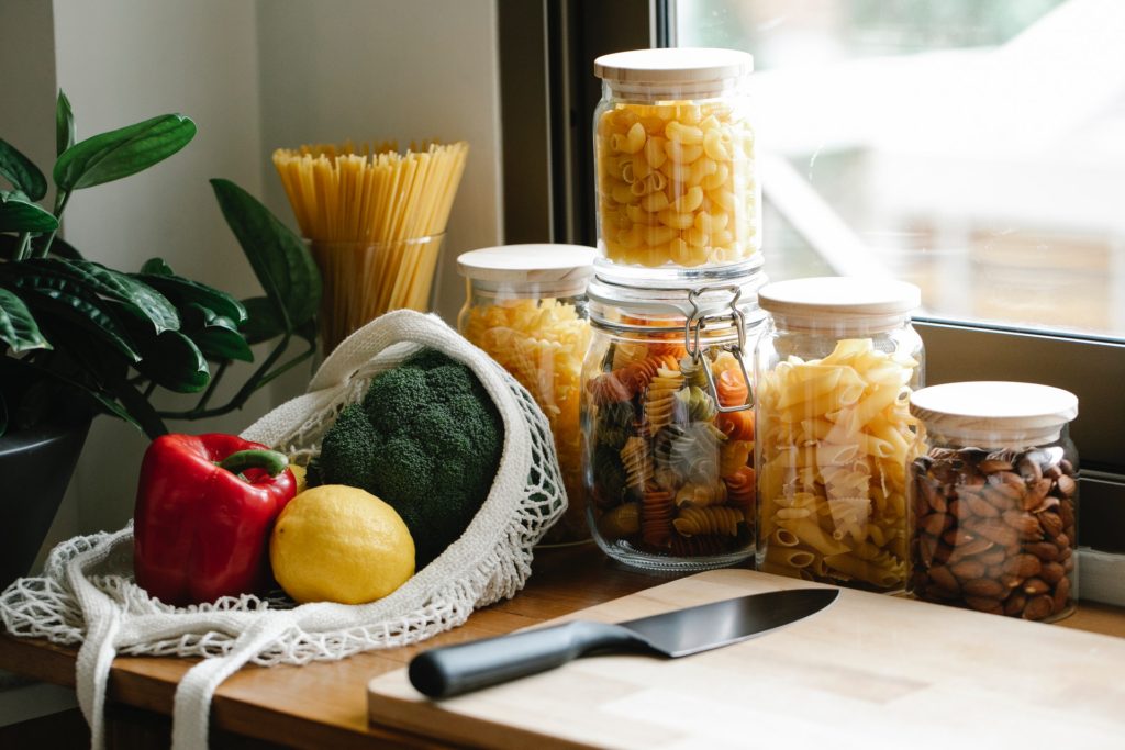 Pasta in bottles and assorted vegetables in the kitchen