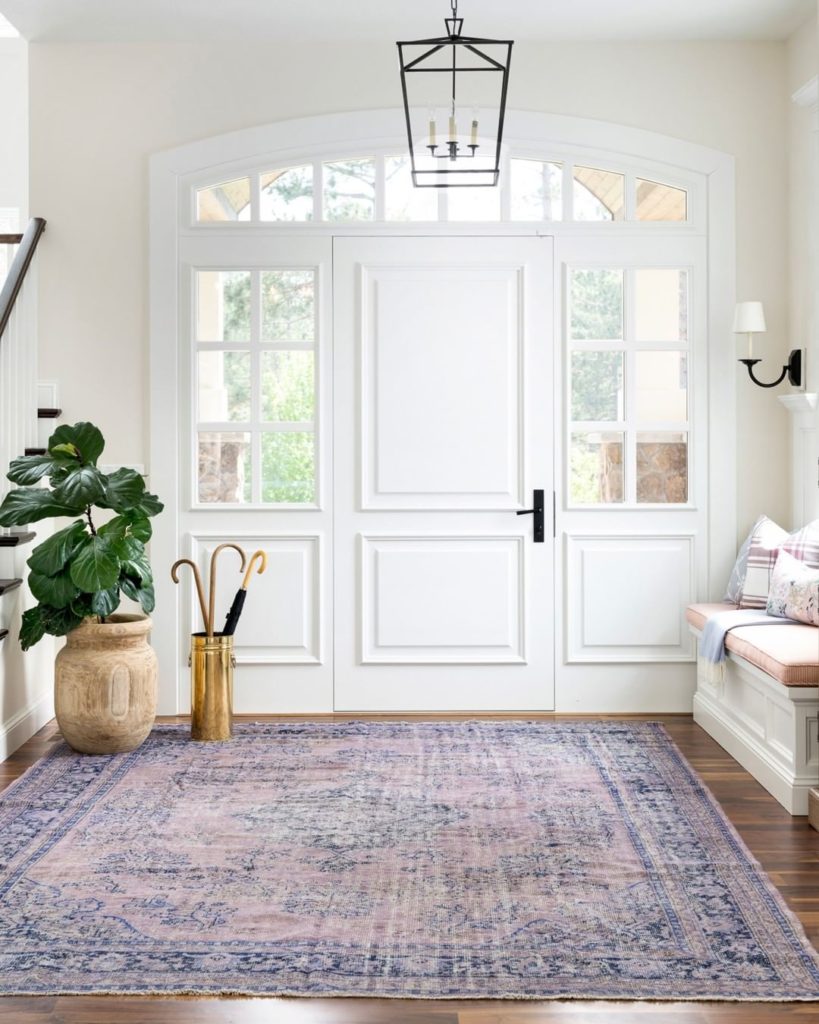 A big pinkish rug in the entryway or foyer.