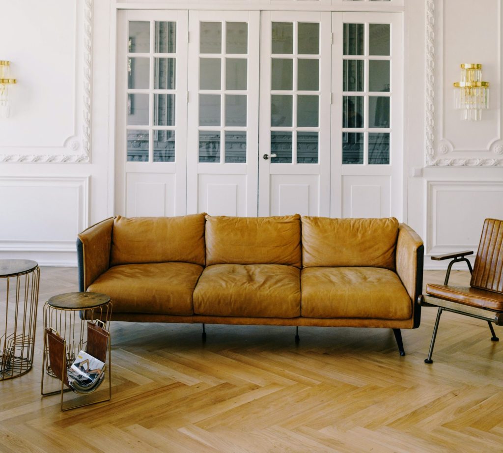 Brown vintage sofa in a French design white living room.